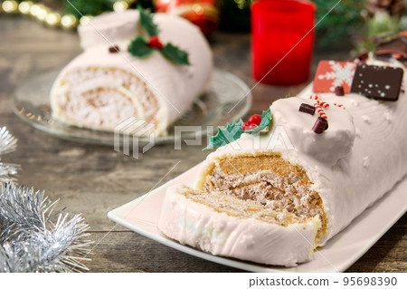 White chocolate yule log cake with christmas lights 95698390