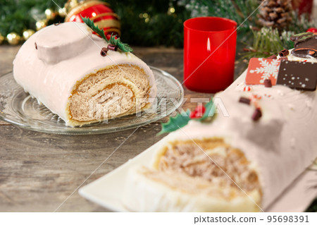 White chocolate yule log cake with christmas lights 95698391