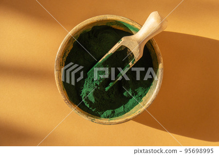 Blue-green algae Chlorella and spirulina powder in bamboo eco bowl. Super powder in spoon. Detox superfood. Natural supplement of algae 95698995
