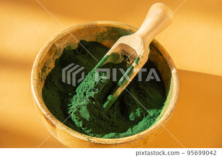 Blue-green algae Chlorella and spirulina powder in bamboo eco bowl. Super powder in spoon. Detox superfood. Natural supplement of algae Blue-green algae Chlorella and spirulina powder in bamboo eco bowl. Super powder in spoon. Detox superfood. Natural supplement of algae 95699042