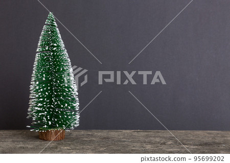 One small Christmas tree on colored background. new year decoration with copy space 95699202