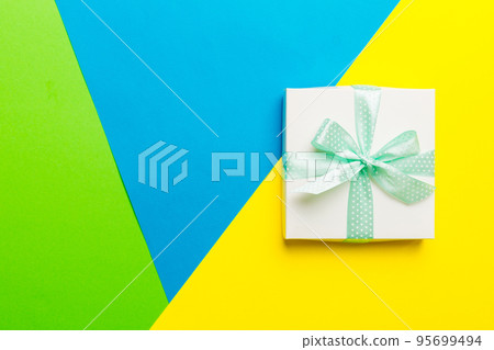 holiday handmade white present tied green ribbon bow top view with copy space. Flat lay holiday background. Birthday or christmas present. Christmas gift box concept with copy space 95699494