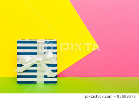 holiday paper present tied yellow ribbon bow top view with copy space. Flat lay holiday background. Birthday or christmas present. Christmas gift box concept with copy space holiday paper present tied yellow ribbon bow top view with copy space. Flat lay holiday background. Birthday or christmas present. Christmas gift box concept with copy space 95699578