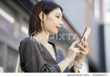 操作智能手機的年輕女子的簡介 95699877