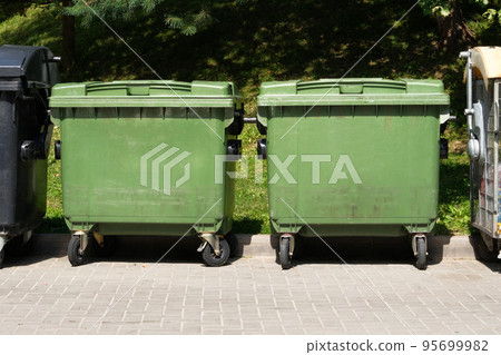 Dustbins being full with garbage. Garbage bins in city community. Green garbage bins in town. Dustbins being full with garbage. Garbage bins in city community. Green garbage bins in town. 95699982