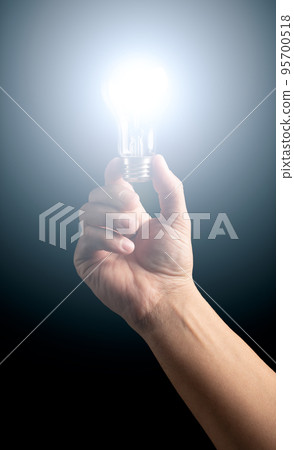 Man's hand holding lighted light bulb. Man's hand holding lighted light bulb. 95700518
