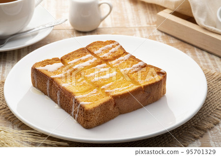 Air fryer grilled butter toast,golden brown crispy bread topped with sugar and sweetened condensed milk on white plate Air fryer grilled butter toast,golden brown crispy bread topped with sugar and sweetened condensed milk on white plate 95701329
