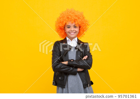 Funny kid in curly redhead wig. Time to have fun. Teen girl with orange hair, being a clown. Happy girl face, positive and smiling emotions. 95701361