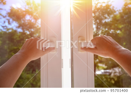 man at home open window on a sunny day. manual open white pvc plastic window at home 95701400