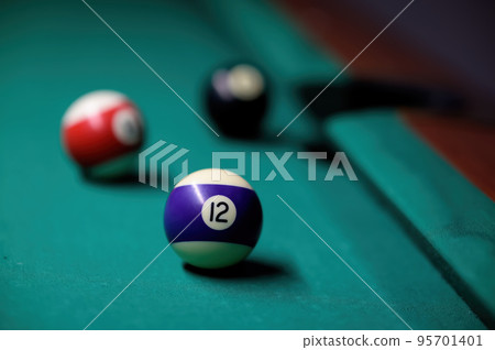 Multi-colored billiard balls on a green table surface. Close-up 95701401