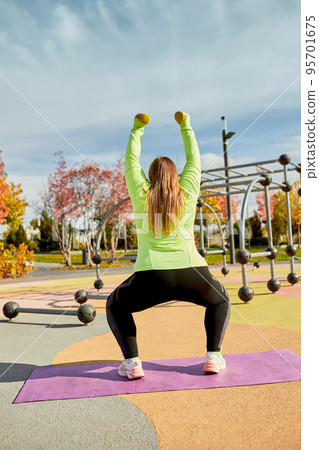 Young plump woman in activewear workout at street public sportsground, outdoors. Weight lost concept. Active sport, health, mood, body positive Young plump woman in activewear workout at street public sportsground, outdoors. Weight lost concept. Active sport, health, mood, body positive 95701675