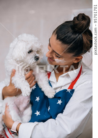 Smiling woman in kitchen holding cute white Maltese dog Smiling woman in kitchen holding cute white Maltese dog 95701701