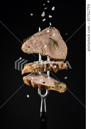 Steak from baked meat with spices sprinkled with sea salt on a black background. Menu idea for a restaurant or hotel Steak from baked meat with spices sprinkled with sea salt on a black background. Menu idea for a restaurant or hotel 95702759