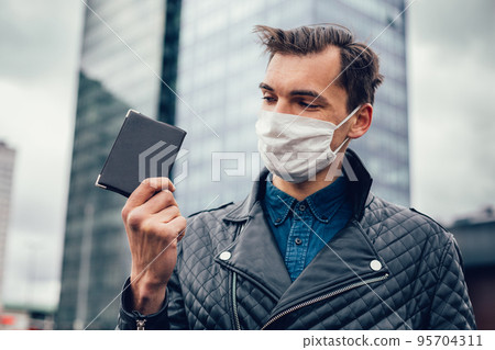 close up. a man with a passport on a city street close up. a man with a passport on a city street 95704311