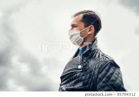 man in a protective mask against the background of a modern city man in a protective mask against the background of a modern city 95704312