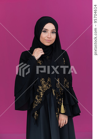beautiful muslim woman in fashinable dress with hijab isolated on modern pink background representing concept of modern islam and ramadan kareem 95704614