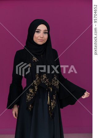 beautiful muslim woman in fashinable dress with hijab isolated on modern pink background representing concept of modern islam and ramadan kareem 95704652