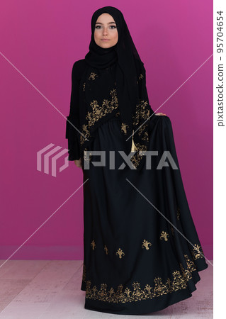 beautiful muslim woman in fashinable dress with hijab isolated on modern pink background representing concept of modern islam and ramadan kareem 95704654