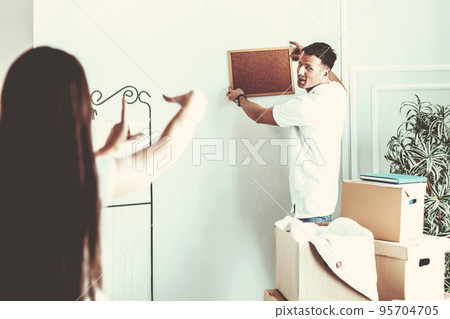 young couple arranging things in their new apartment . 95704705