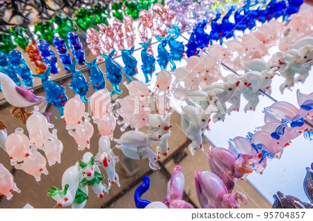 Colorful animals made from murano glass on a mirror 95704857