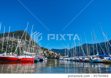 Boats on the lake of Lugano on a summer day with sunny blue sky Boats on the lake of Lugano on a summer day with sunny blue sky 95704968