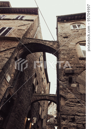 Bridge passages between two medieval stone buildings 95704997