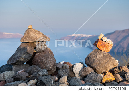 Stones shapes on a hill with the Santorini Caldera on the background 95705106