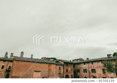 Old roofs of San Gimignano with cloudy sky background Old roofs of San Gimignano with cloudy sky background 95705239