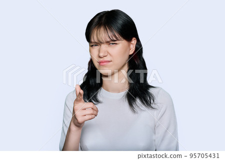 Young woman making grimace, showing trouble, on white background 95705431