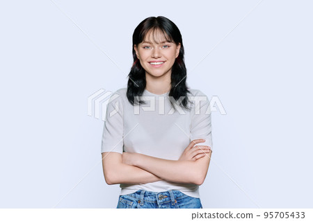 Portrait of positive young female with arms crossed over white background 95705433