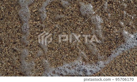 Texture of coarse sea sand close-up, small pebbles, sea water with foam For design, background, postcards, collages and compositions 95706170