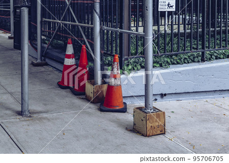 Orange Road Traffic Cone with White Stripes on Street 95706705