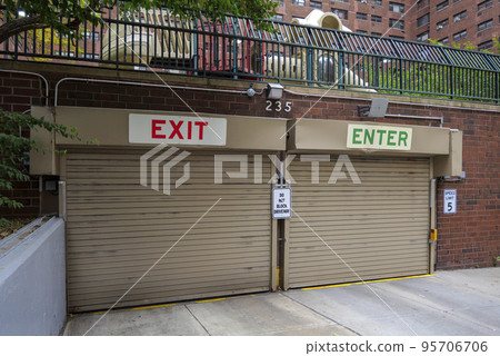 Entrance to the underground garage. Gate to the garage in the building. Office building is brown. Entrance to the underground garage. Gate to the garage in the building. Office building is brown. 95706706
