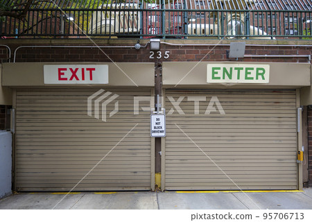 Entrance to the underground garage. Gate to the garage in the building. Office building is brown.  95706713