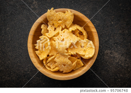 Halloween crispy bat shaped chips in bowl. Halloween crispy bat shaped chips in bowl. 95706748