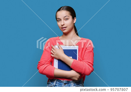 Portrait of teenage high school student on blue color studio background 95707807