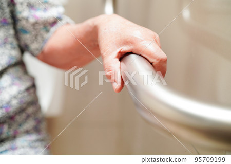 Asian elderly old woman patient use toilet support rail in bathroom, handrail safety grab bar, security in nursing hospital. Asian elderly old woman patient use toilet support rail in bathroom, handrail safety grab bar, security in nursing hospital. 95709199