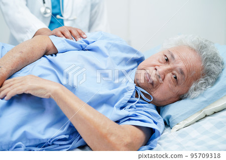 Doctor taking care, help and encourage Asian elder senior woman patient in clinic hospital. 95709318