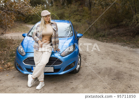 Sexy girl poses outside the car in autumn in fashionable clothes Sexy girl poses outside the car in autumn in fashionable clothes 95711850
