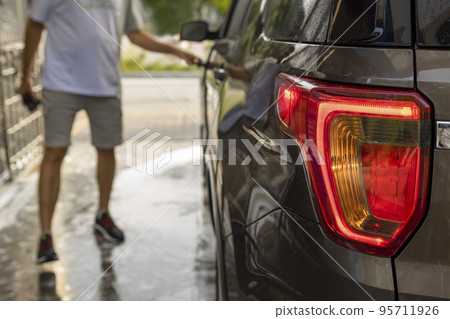 the rear stop of the car is covered in soap foam . self-service car wash the rear stop of the car is covered in soap foam . self-service car wash 95711926