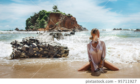 Beautiful young woman in sexy bikini standing at sea beach Beautiful young woman in sexy bikini standing at sea beach 95711927