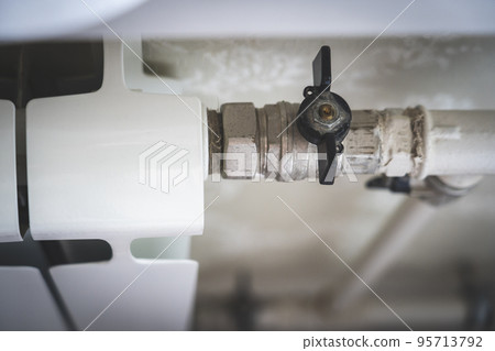 turns the heating on and off. Radiator Heating On The Background of the Wall 95713792