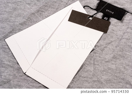 A closeup shot of a blank clothing tag on a string for a price label on a cloth 95714330