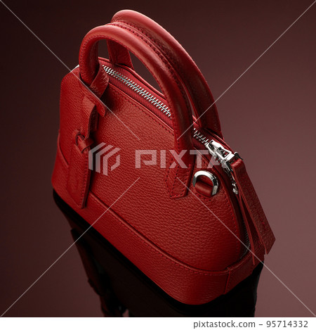 A closeup shot of a luxury red leather bag A closeup shot of a luxury red leather bag 95714332