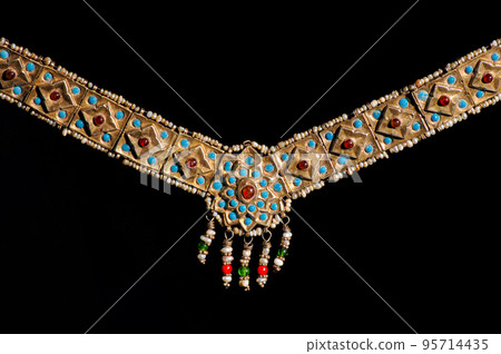 An India vintage jewelry pendant with precious stones on a black background An India vintage jewelry pendant with precious stones on a black background 95714435