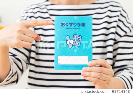 A casual middle-aged woman with a medicine notebook 95714548