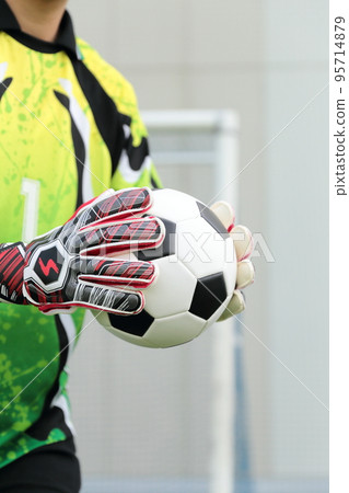 Goalkeeper man catching a soccer ball 95714879