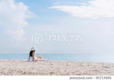 Summer vacation on the beach, Young woman relaxing on the beach with sea view 95714956