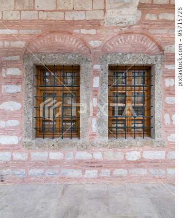 Two adjacent wooden arched windows in a red and white stone bricks wall, near Eyup Sultan Mosqoe, Istanbul, Turkey Two adjacent wooden arched windows in a red and white stone bricks wall, near Eyup Sultan Mosqoe, Istanbul, Turkey 95715728