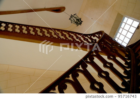 View bottom up on beautiful luxury staircase with wooden railings 95716743